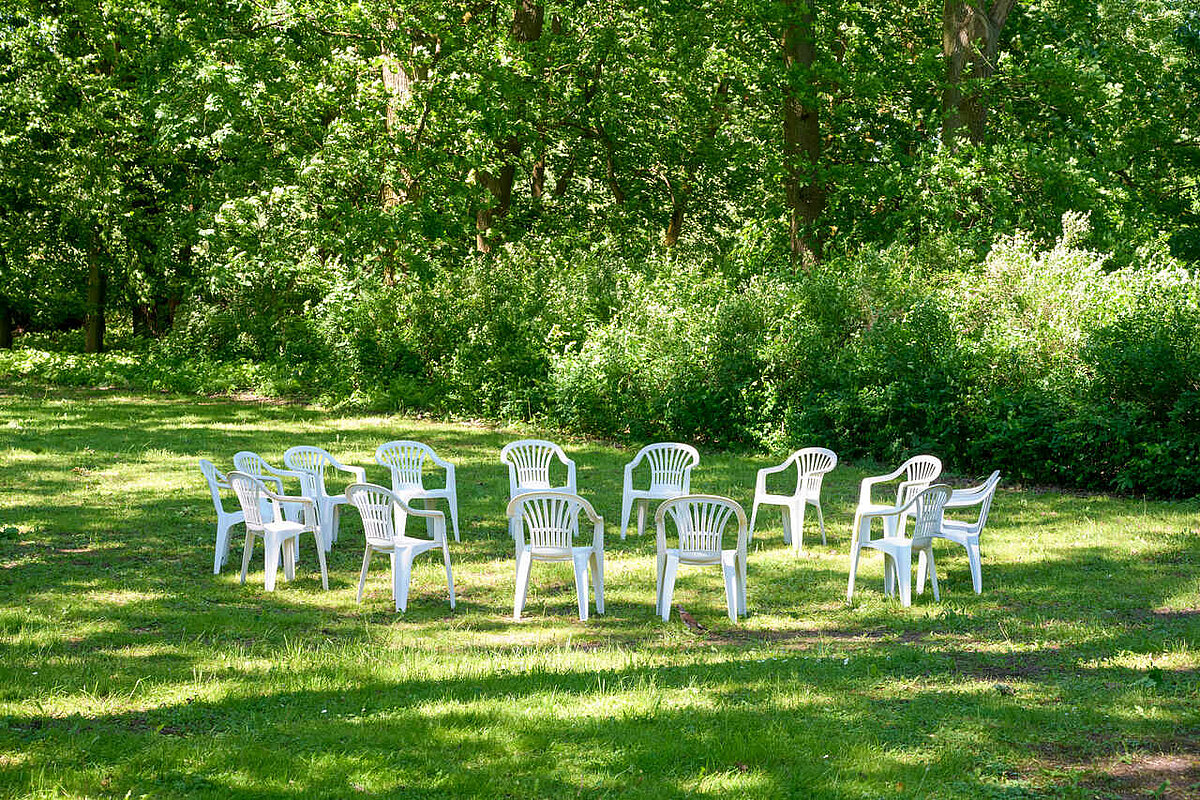 Garten Sitzkreis mit weißen Stühlen im Grünen